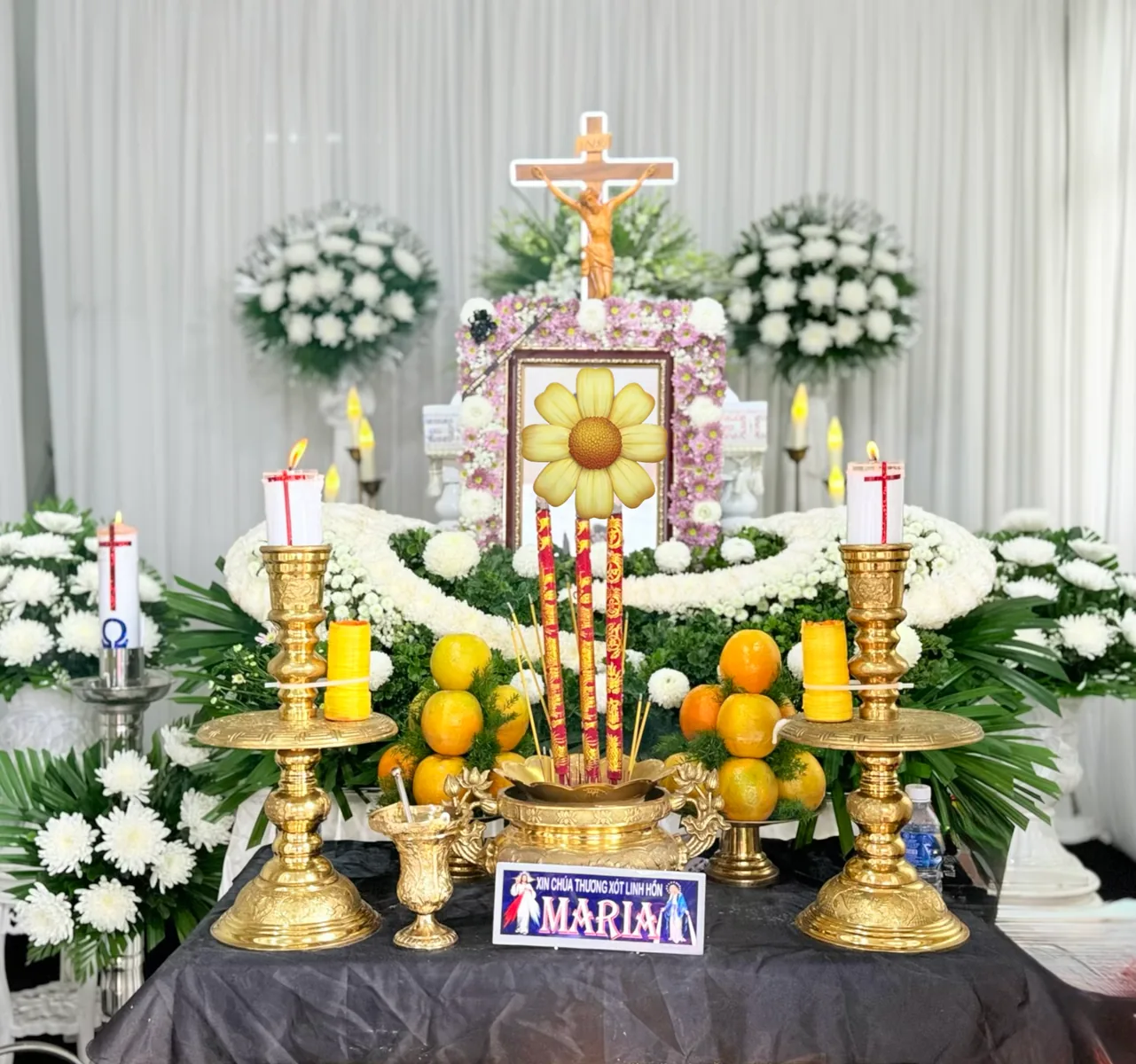 Bàn vong với di ảnh, thánh giá, nến và hoa trắng