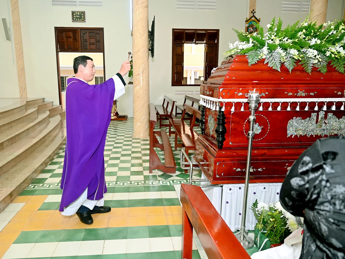 Linh mục cử hành nghi thức bên linh cữu