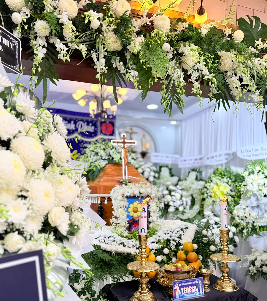 Góc nhìn qua khung hoa trắng đến bàn vong và thánh giá