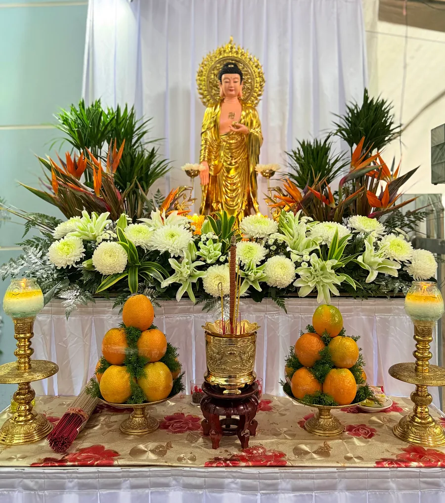 Bàn Phật với hoa trắng, trái cây và hương đèn
